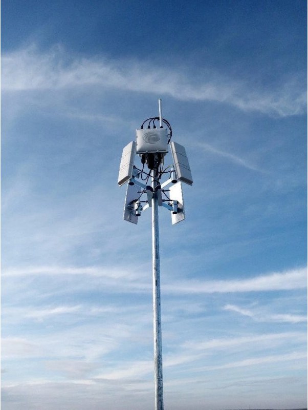 A fixed drone-detection receiver with four panel antennas on a pole against the sky